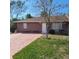 Charming single-story home with brick facade, mature tree, and well-maintained lawn at 1420 Thousand Roses S Dr, Lake Wales, FL 33853