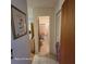 Hallway with tile flooring leading to a bathroom, with a closet and a rose-themed painting on the wall at 1420 Thousand Roses S Dr, Lake Wales, FL 33853