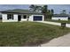 Charming single-story home featuring a bright blue garage door and spacious front lawn for sale at 15122 Sw 61St Court Rd, Ocala, FL 34473