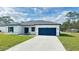 Charming single-story home featuring a blue garage door, and well-manicured lawn at 15122 Sw 61St Court Rd, Ocala, FL 34473