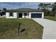 Charming single-story home with a well-manicured lawn, inviting curb appeal, and a dark blue garage door at 15122 Sw 61St Court Rd, Ocala, FL 34473