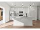 Modern white kitchen with stainless steel appliances, quartz countertop island, and stylish pendant lighting at 15122 Sw 61St Court Rd, Ocala, FL 34473