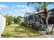 Side yard with lush landscaping and a view of the pool at 16143 Palmetto Hill St, Clermont, FL 34714