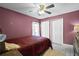 Bright bedroom with a red and white comforter and ceiling fan at 16143 Palmetto Hill St, Clermont, FL 34714