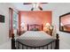 Bedroom with coral accent wall, metal bed frame and plenty of natural light at 176 Nandina Ter, Winter Springs, FL 32708