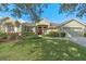 Green house exterior with red door, landscaping, and driveway at 176 Nandina Ter, Winter Springs, FL 32708