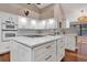 White kitchen with center island, double oven, and stone backsplash at 217 Pleasant Valley Dr, Daytona Beach, FL 32114