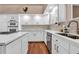 Modern white kitchen with stainless steel appliances and hardwood floors at 217 Pleasant Valley Dr, Daytona Beach, FL 32114