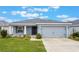 Single-story home with gray exterior, attached garage, and landscaped lawn at 220 Foxtail Loop, Davenport, FL 33837