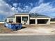 New home's exterior featuring block construction, spacious two-car garage, and a modern design under a partly cloudy sky at 2710 Ravencliffe Ter, Oviedo, FL 32765