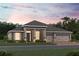 Two-story home with a gray exterior, three-car garage, and landscaping at 2710 Ravencliffe Ter, Oviedo, FL 32765