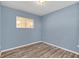 Simple bedroom with light blue walls and wood-look flooring at 303 Foxhill Ct, Debary, FL 32713