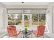 Bright sunroom with two red chairs and a view of the backyard at 303 Foxhill Ct, Debary, FL 32713