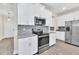 Modern kitchen with white cabinets, granite countertops, and stainless steel appliances at 3138 Dark Sky Dr, Harmony, FL 34773