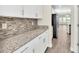 White kitchen cabinets, granite countertops, and stainless steel appliances at 3138 Dark Sky Dr, Harmony, FL 34773