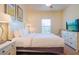 Spacious bedroom with a queen-size bed, neutral decor, and a large TV at 3201 Gold Ln, Kissimmee, FL 34747