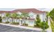 Light-blue townhouses with red roofs, palm trees, and a walkway at 3201 Gold Ln, Kissimmee, FL 34747