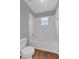 Clean bathroom with a bathtub, toilet and wood-look flooring at 370 Aldershot Ct, Kissimmee, FL 34758