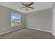 This carpeted bedroom features a ceiling fan, a window with great light and neutral walls at 370 Aldershot Ct, Kissimmee, FL 34758