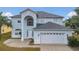 Two-story house with light blue exterior, white garage door, and landscaping at 370 Aldershot Ct, Kissimmee, FL 34758