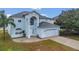 Two-story light blue house, white garage door, and a spacious front yard at 370 Aldershot Ct, Kissimmee, FL 34758