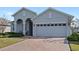 Gray house with a two-car garage and a brick paved driveway at 3999 Night Heron Dr, Sanford, FL 32773