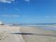 Expansive beach view with a pier in the distance under a bright blue sky at 400 Auburn Dr # 3, Daytona Beach, FL 32118