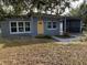 Gray house with yellow door and carport, showcasing curb appeal at 4400 Southmore Dr, Orlando, FL 32812