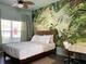 Bedroom with tropical mural, comfortable bed, and home office space at 4560 Yellowgold E Rd # 108, Kissimmee, FL 34746