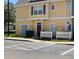 Exterior view of a yellow two-story building with white picket fence at 4560 Yellowgold E Rd # 108, Kissimmee, FL 34746