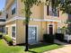 Inviting exterior of a two-story townhome with a red door and well-manicured landscaping at 4560 Yellowgold E Rd # 108, Kissimmee, FL 34746