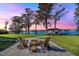 Fire pit and seating area overlooking the lake at sunset at 491 Carolyn Dr, Oviedo, FL 32765