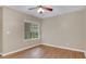 Comfortable bedroom with wood flooring, neutral walls, a ceiling fan, and a sunny window at 505 Harvard Pl, Apopka, FL 32703