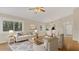 Sunlit living room features hardwood floors, neutral paint, and a view of lush greenery at 505 Harvard Pl, Apopka, FL 32703