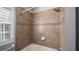 Bathroom with shower/tub combo, tile surround, and window at 5419 Baldwin Park St, Orlando, FL 32814