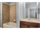 Bathroom with a vanity, tub, and tile shower surround at 5419 Baldwin Park St, Orlando, FL 32814