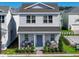 Two-story house with gray siding, a front porch, and landscaping at 5586 Stockade Blvd, St Cloud, FL 34771