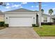 House exterior with a white garage door and landscaping at 627 Copeland Dr, Haines City, FL 33844