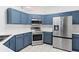 Modern kitchen with stainless steel appliances and blue cabinets at 627 Copeland Dr, Haines City, FL 33844