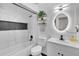 Modern bathroom with a white vanity, marble tile, and a bathtub at 7729 Country Pl, Winter Park, FL 32792