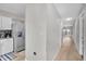 Clean hallway with light walls and wood-look floors leading to the kitchen at 7729 Country Pl, Winter Park, FL 32792