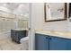 Bathroom with blue vanity, a bathtub, and a separate toilet area at 820 Spring Oak Cir, Orlando, FL 32828