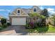 Attractive two-story house with stone and beige siding, a three-car garage, and lush landscaping at 820 Spring Oak Cir, Orlando, FL 32828