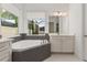 Spa-like bathroom with corner soaking tub and gray tile at 8361 Ludington Cir, Orlando, FL 32836