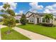 Home's exterior showcases a stone facade and lush landscaping at 8361 Ludington Cir, Orlando, FL 32836