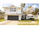 A beautiful two-story white home with a grey garage door and mature palm trees at 862 Shriver Cir, Lake Mary, FL 32746