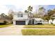 A beautiful two-story white home with a grey garage door and mature palm trees at 862 Shriver Cir, Lake Mary, FL 32746