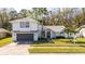 A beautiful two-story white home with a grey garage door and mature palm trees at 862 Shriver Cir, Lake Mary, FL 32746