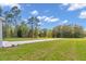 Expansive backyard featuring well-maintained lawn, mature trees and a long concrete driveway at 9095 Sw 125Th Ter, Dunnellon, FL 34432