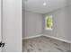 Clean bedroom featuring wood-look tile floors, natural light, and neutral gray walls at 9095 Sw 125Th Ter, Dunnellon, FL 34432